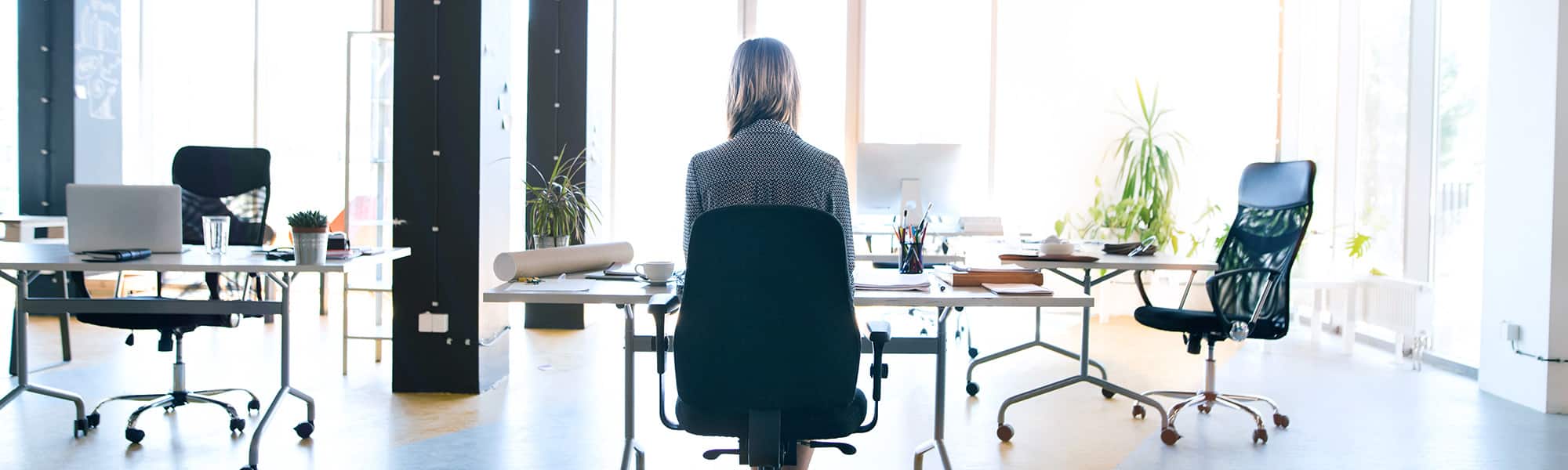 Woman with desk job sitting down. Prolonged sitting is unhealthy. Massage can mitigate the effects