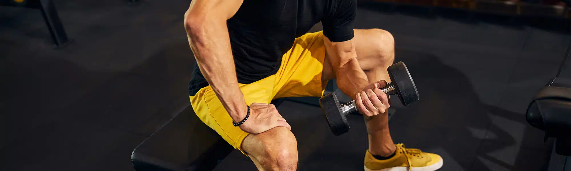 Man curling dumbell as an example of an athlete that can benefit from a luxury massage chair